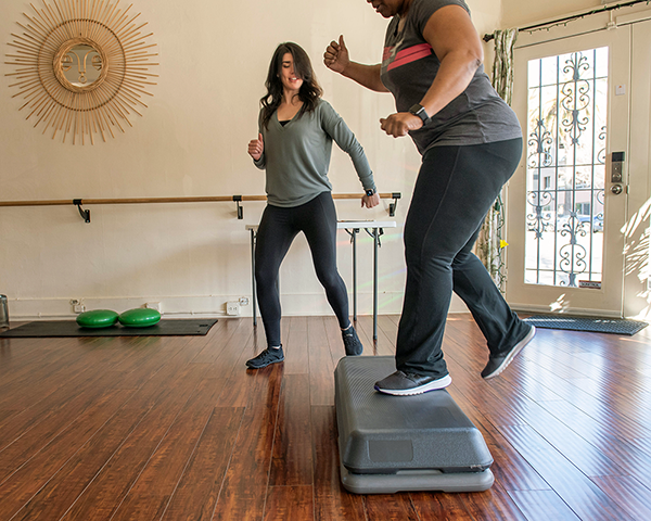 A fitness instructor leading members in a workout to move beyond cancer