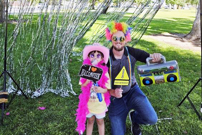 A dad ad his daughter enjoying the photobooth at a Parkinson's benefit walk in Fresno
