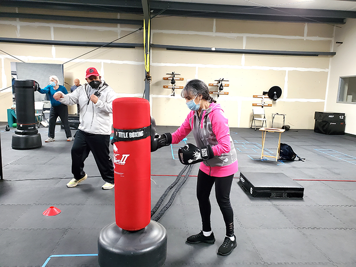 Boxer with Parkinson's disease hitting heavy bag